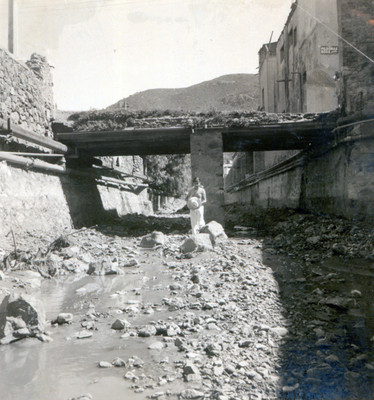 Mujer junto a un puente en ruinas, durante trabajos de desazolve del Río de las Avenidas