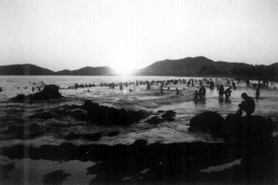 Vista parcial de una playa con turistas durante el atardecer