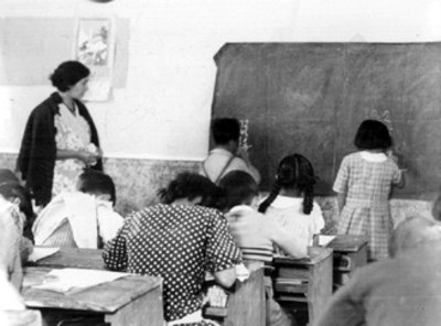 Niños escriben en el pizarrón durante una clase