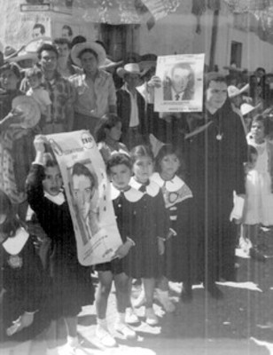 Niños y mujer muestran cartel de la campaña electoral de López Mateos
