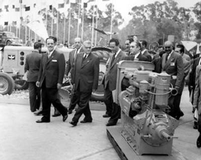 Gilberto Loyo y empresarios observan motor industrial Diesel durante exposición