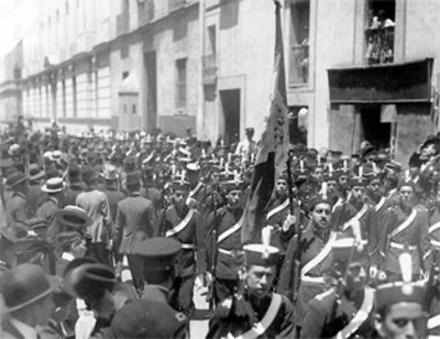 Estudiantes militarizados de la Escuela Nacional Preparatoria desfilan por una calle de la Cd. de México
