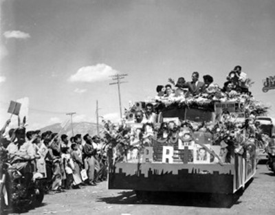 Adolfo López Mateos rodeado de mujeres a bordo de camión de carga, durante su campaña electoral