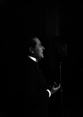 Alfonso Ortiz Tirado cantando ante el micrófono, durante un espectacúlo