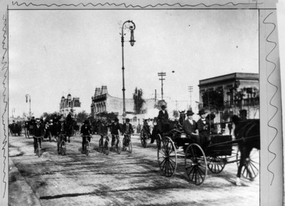 Desfile de carruajes y hombres en bicicleta el Paseo de la Reforma