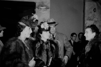 Ezequiel Padilla Peñaloza, Secretario de Relaciones Exteriores acompañado de mujeres elegantes durante un evento en un salón