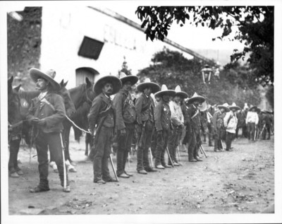 Revolucionarios zapatistas y sus caballos afuera de una hacienda