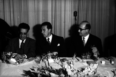Manuel Palavacini, Ramón Beteta y otros, conviviendo en la mesa, durante un banquete en un salón