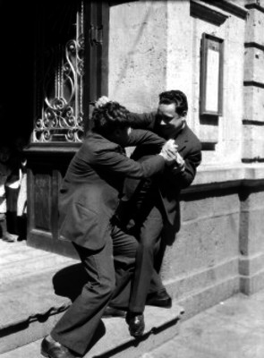 Joaquín Pardave arce peleando con otro actor frente a un edificio durante la filmación de una película