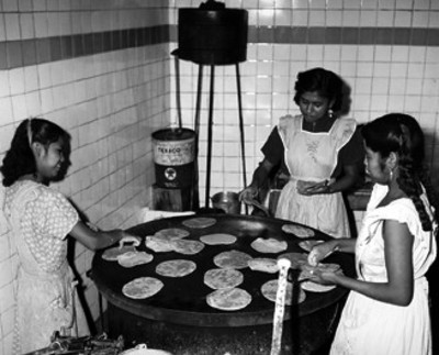 Mujeres hacen tortillas en comal