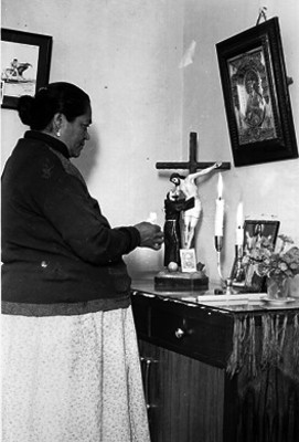 Mujer coloca vela a un cristo