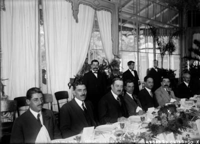 Francisco Pérez, Severino Herrera y otros hombres sentados a la mesa, durante un banquete ofrecido a Alvaro Obregón, en el restaurante Chapultepec