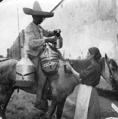 Hombre vende leche a mujer