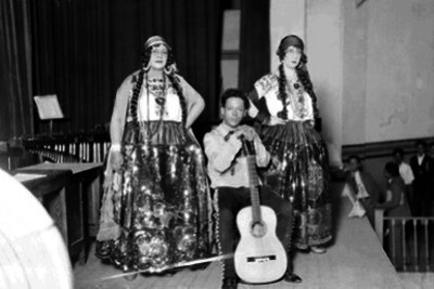 María Parras con Juan Alberto Villegas y Emilia Tinoco vestidos con trajes folclóricos durante un espectáculo en un teatra, retrato de grupo