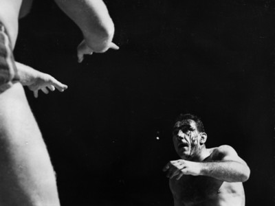 Luchador con el rostro cubierto de sangre durante pelea deportiva