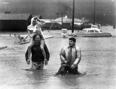 Damnificados caminan por una calle inundada