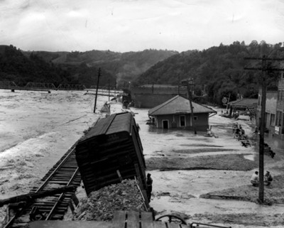 Gente entre los escombros de poblado inundado, vista parcial