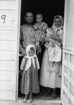 Familia en la puerta de una vivienda, retrato de grupo