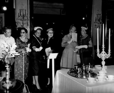 Mujeres observan adornos florales. de las mesas premiadas