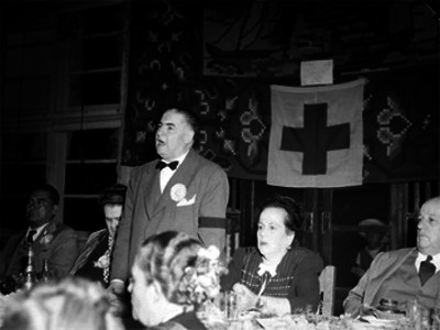 Alejandro Quijano, Licenciado acompañado de su esposa y otras personalidades hace uso de la palabra durante un banquete de la Cruz Roja