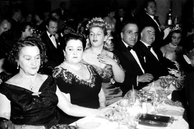 Alejandro Quijano y esposa, acompañados por varias personas en la mesa, durante un banquete