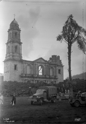 Gente con camiones frente a la iglesia de "San Juan" rodeada por material volcánico
