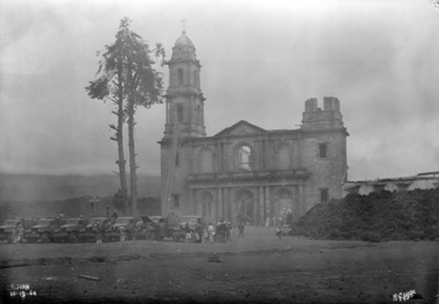 Gente con camiones de carga transportan las pertenencias de los damnificados, estacionados en el atrio de la iglesia de "San Juan"
