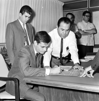 Ejecutivo firma documentos en una oficina en persona de otros hombres