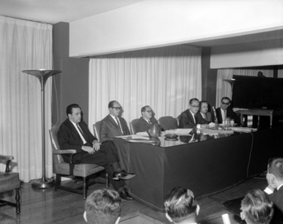 Hombres en mesa directiva durante convención de contadores públicos