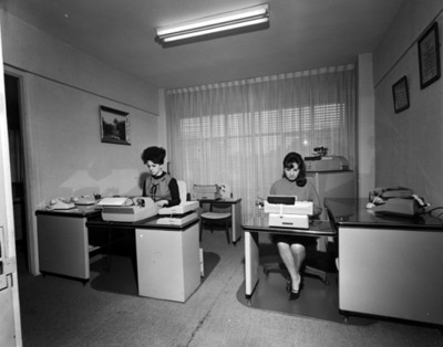 Secretarias trabajan con máquinas de escribir en una oficina