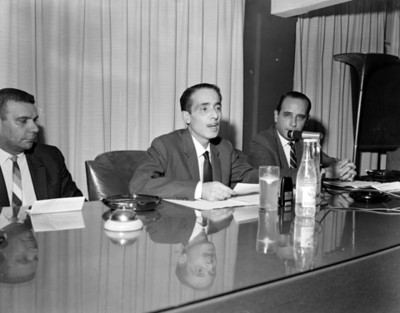 Hombre habla en mesa directiva durante convención