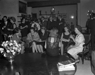 Hombres y mujeres reunidos en la sala de una casa
