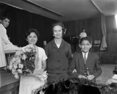 Eva Samano de López Mateos junto a niños en un auditorio después de festival escolar, retrato de grupo