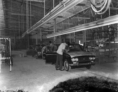 Obreros colocan limpiaparabrisas a automóvil "Bluedird" en planta Nissan