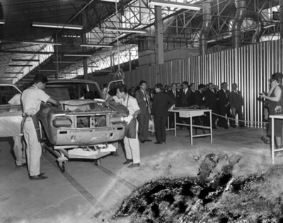 Obreros demuestran ensamblaje de automóvil durante inaguración de planta Nissan Mexicana