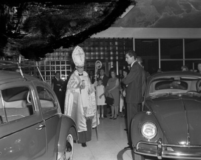 Sacerdote y gente durante bendición de una agencia automotríz Volkwagen