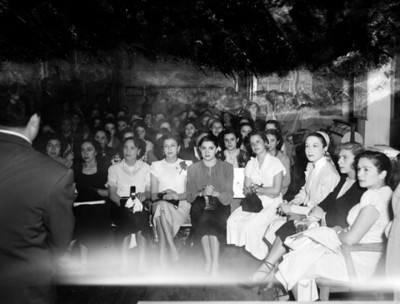Mujeres sentadas en el salón de una tienda departamental observan a un hombre