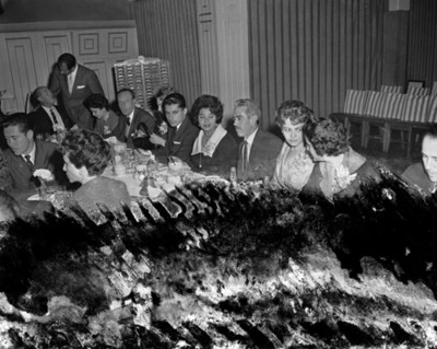 Hombres y mujeres durante banquete en un salón