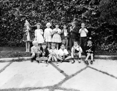 Niñas toman refresco en el patio de una casa durante fiesta infantil, retrato de grupo
