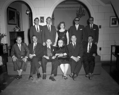 Hombres y mujeres en la sala de una casa, retrato de grupo