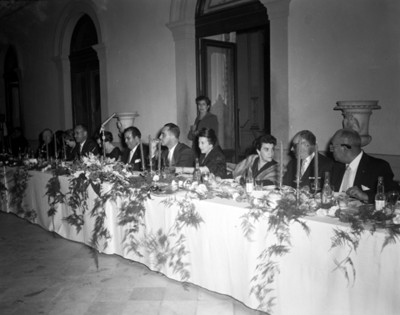 Hombres y mujeres durante banquete en un salón