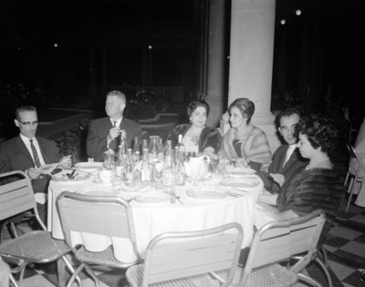 Hombres y mujeres en comedor durante banquete en un salón