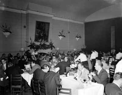 Hombres durante banquete en un salón, vista general