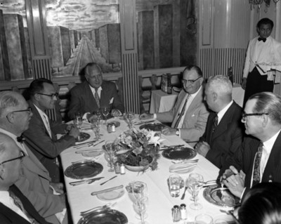 Hombres sentados conversan junto a una mesa de un restaurante