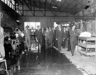 Empresarios recorren instalaciones en una planta automotríz