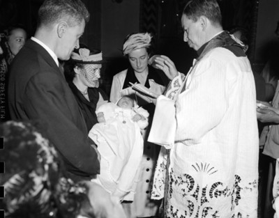 Sacerdote bendice a bebé durante bautizo