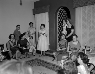 Mujeres y hombres durante reunión social en la sala de una casa