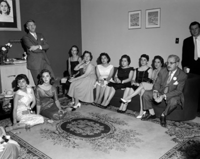Mujeres y hombres durante reunión en la sala de una casa, retrato de grupo