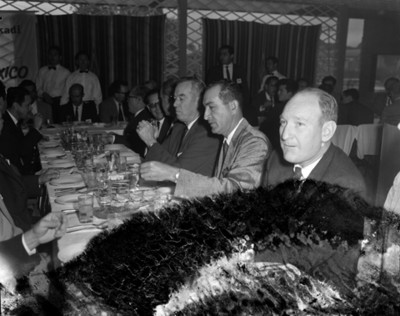 Hombres conversan junto a una mesa