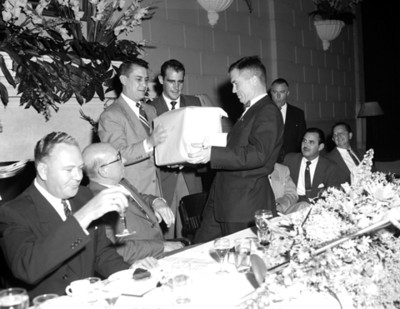 Hombres entregan regalo durante evento